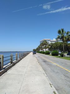 Concrete walk along The Battery, Charleston, SC, with house and palmetto trees.