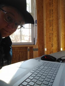 Me with my laptop on a folding table in our unfinished garage / office.